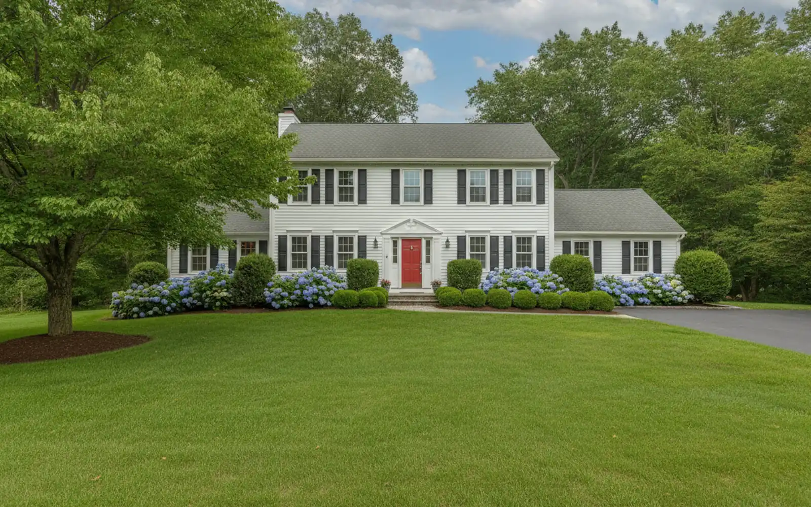 Lush green striped lawn in front of a colonial home in summer